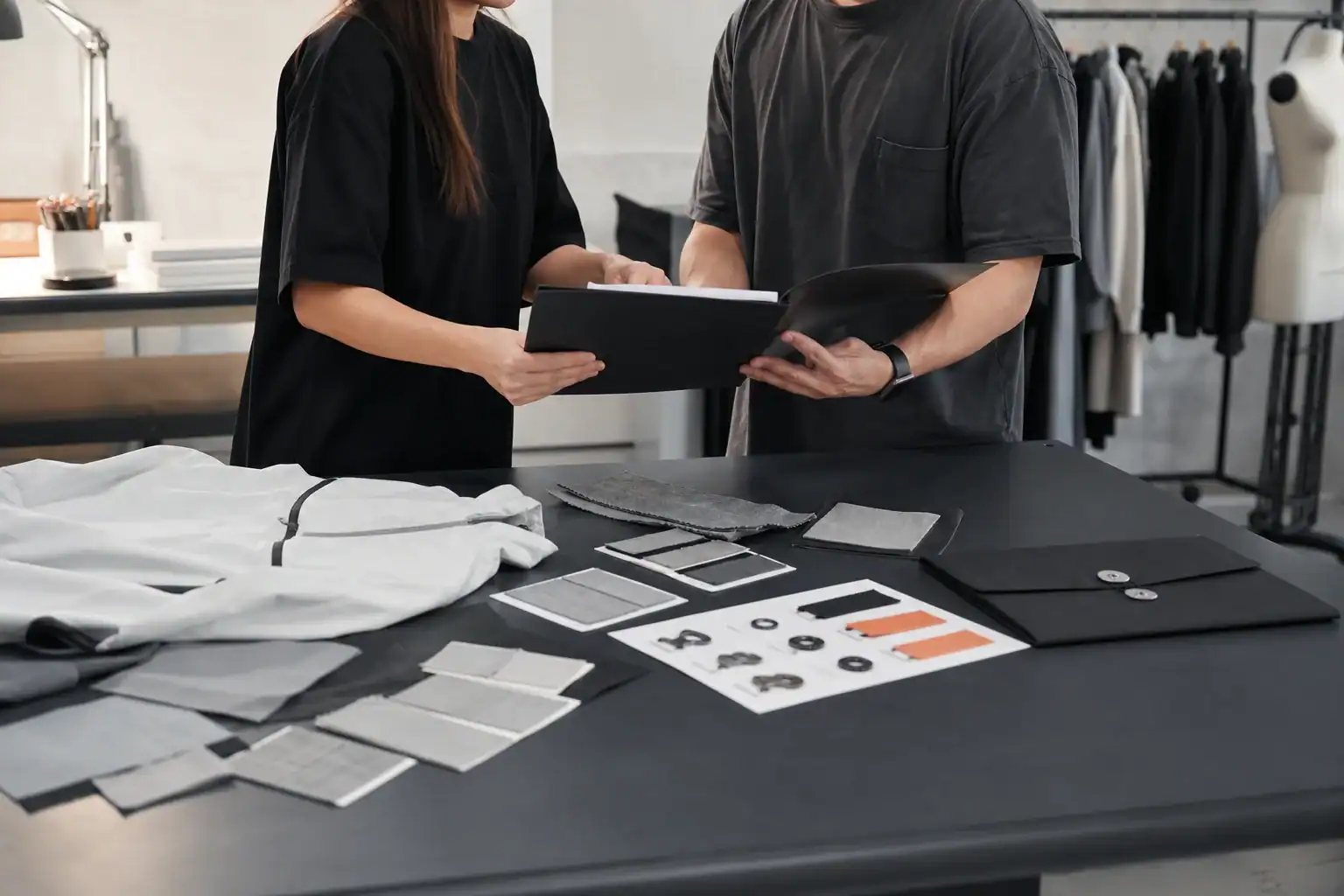 AI-generated illustrative apparel project intake scene with a confidential tech pack, fabric swatches and unbranded activewear sample
