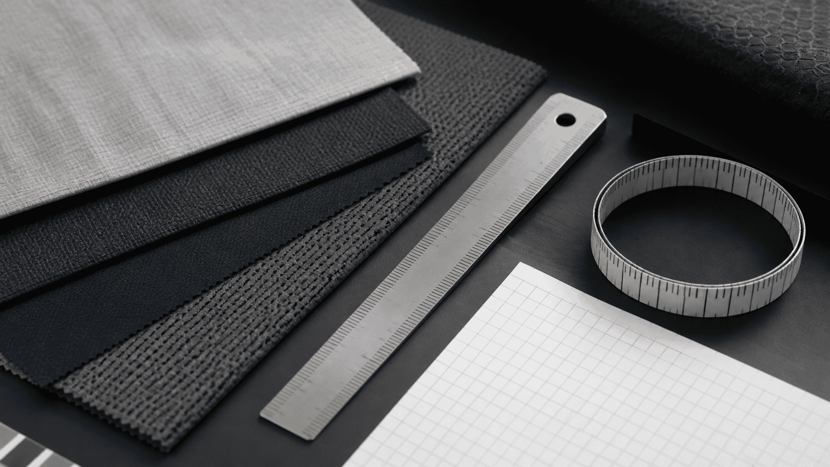 Layered performance fabric swatches, a metal ruler, and a blank measurement grid representing unit conversion