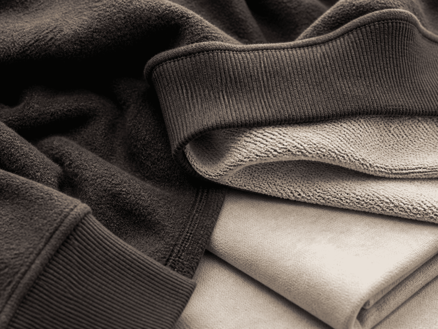 Close-up of layered sweatshirts showing fabric textures and colors.
