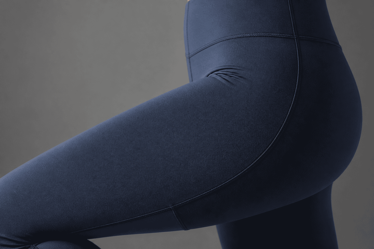 Close-up of navy blue custom activewear fabric with detailed stitching.