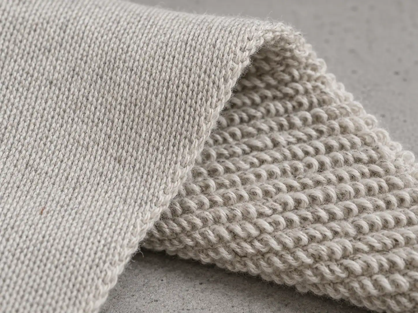 Close-up of smooth French terry face beside its unbrushed loopback reverse