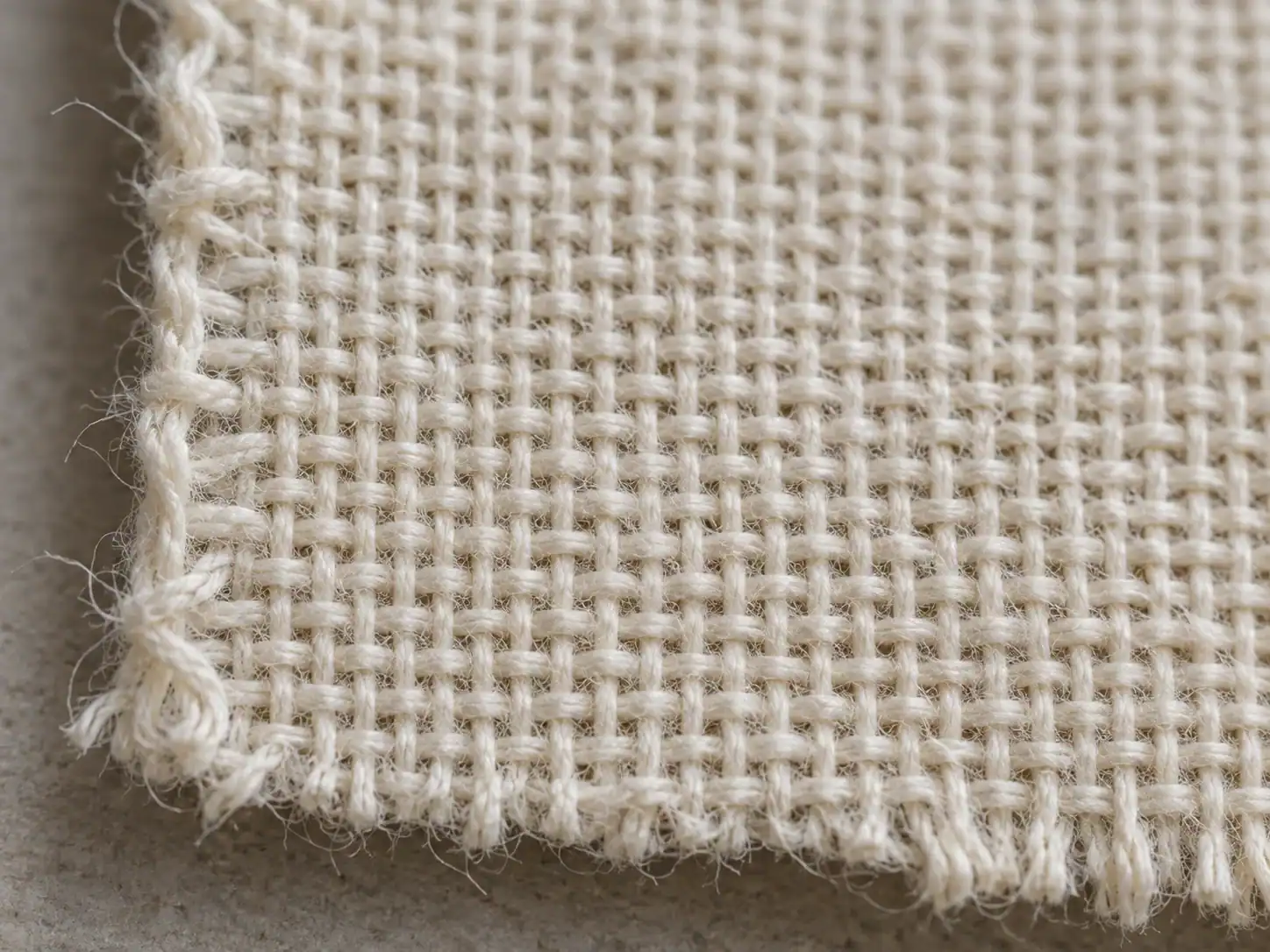 Macro view of plain weave muslin fabric with visible warp and filling yarns