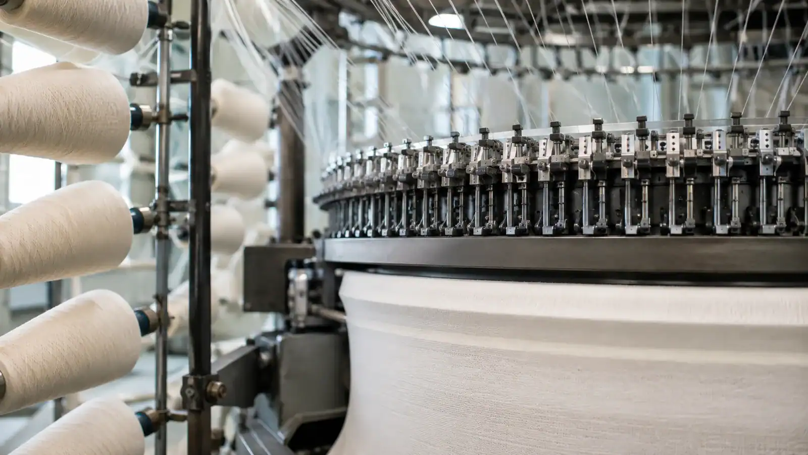 Fabricación textil con máquinas de coser industriales y carretes de tela.