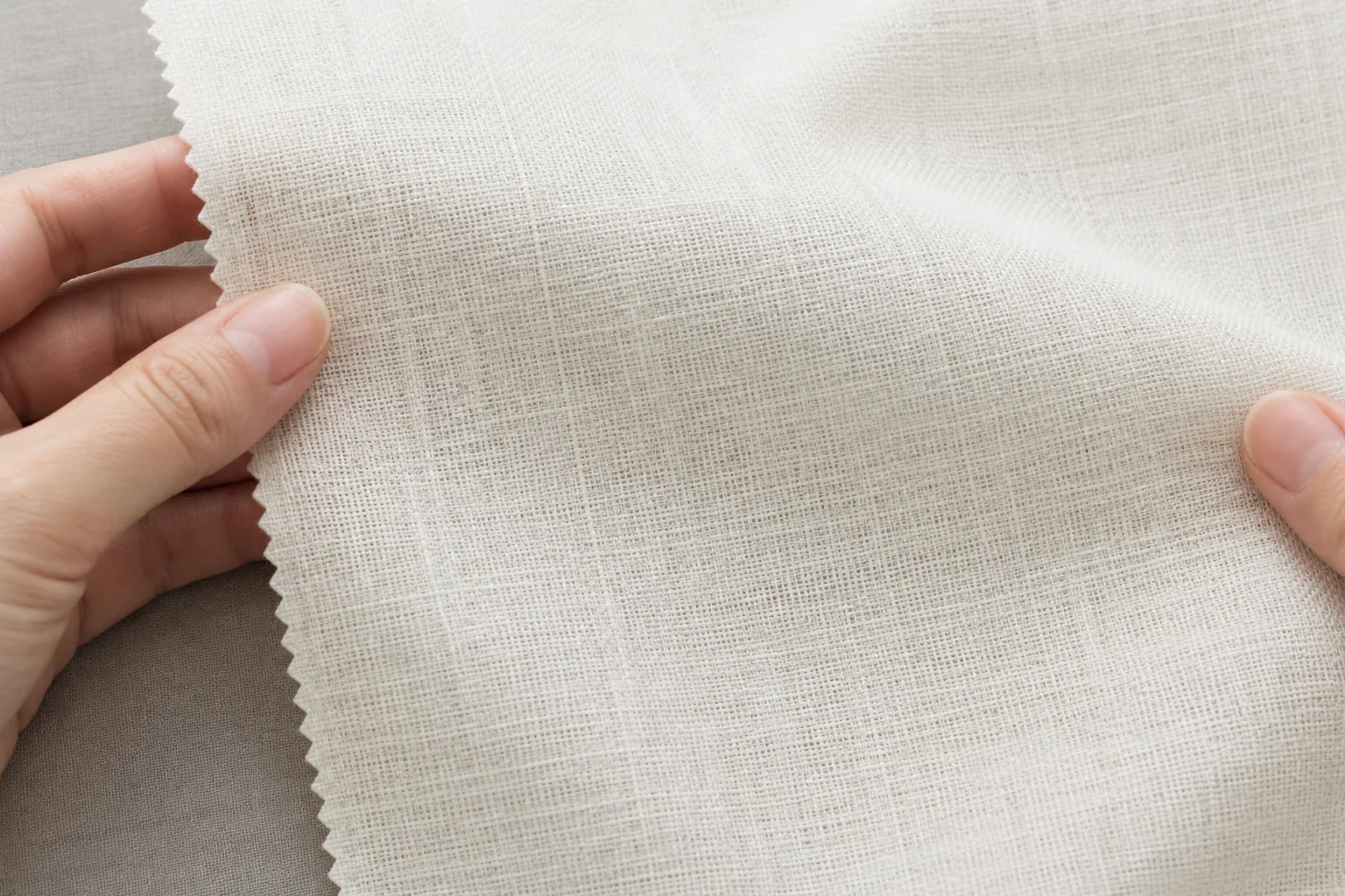 Close-up of white poplin fabric with fine weave texture.
